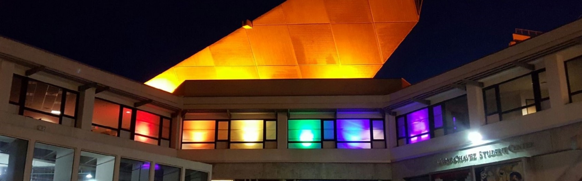 Cesar Chavez Student Center with rainbow lights in the windows